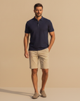 Polo uomo in cotone piqué blu navy indossata, vestibilità regular