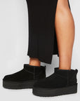 UGG Classic Ultra Mini Platform Black stivaletti con zeppa donna in pelle scamosciata e montone nero, indossate