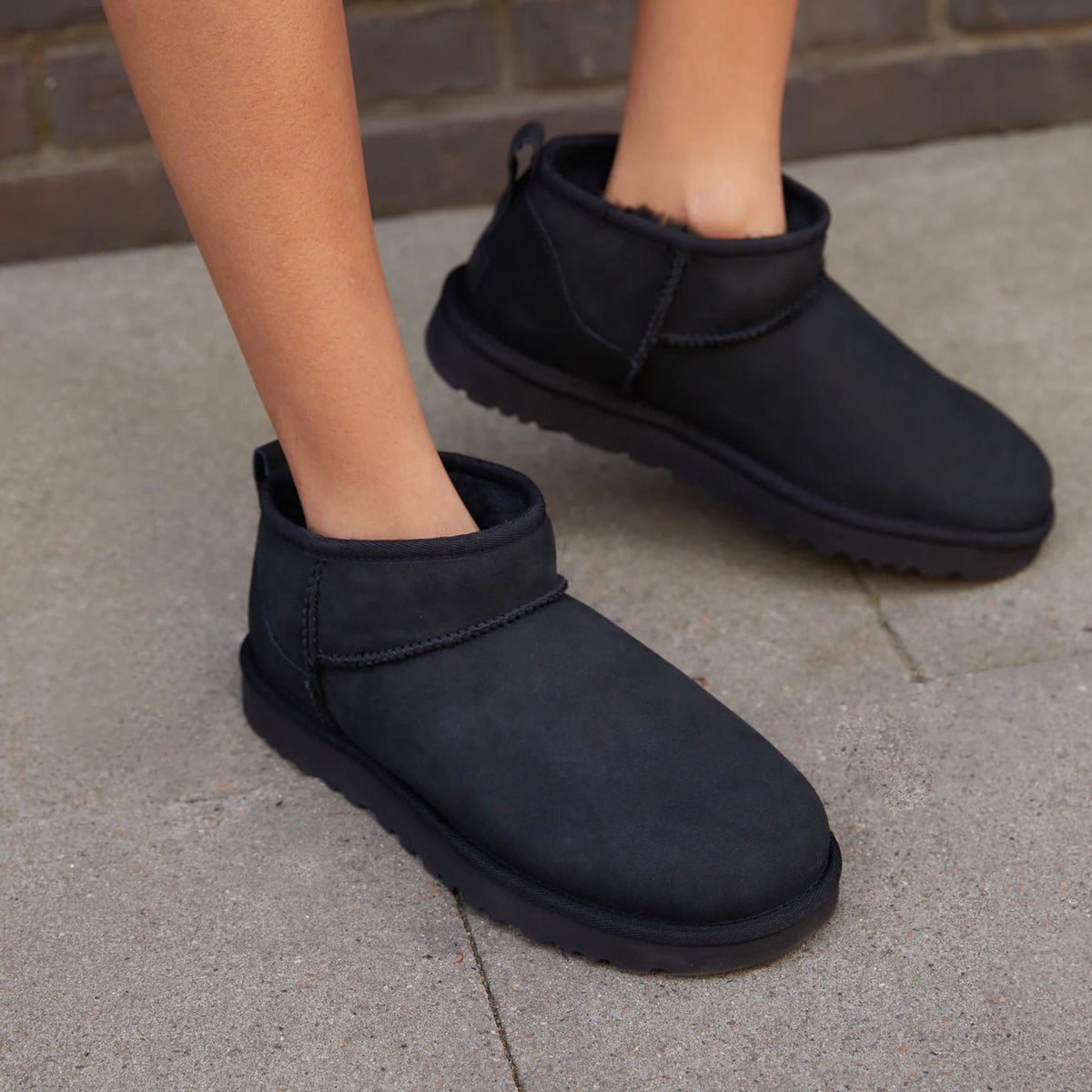 UGG Classic Ultra Mini Black stivaletti donna in pelle scamosciata e montone nero, indossate